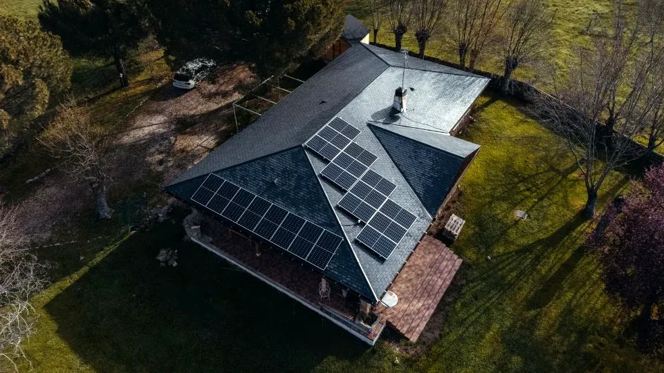Vista aérea de una vivienda unifamiliar con placas solares en el tejado, que vierte sus excedentes a la red