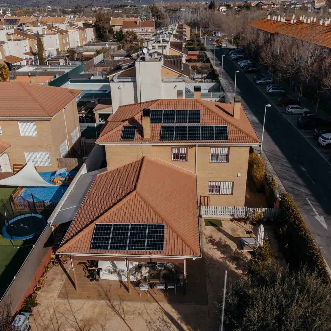 Placas solares instaladas por Lumio en el tejado de teja de una vivienda con piscina