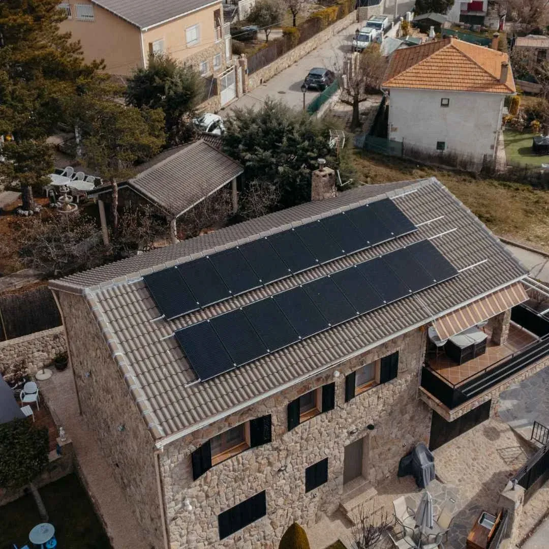 Placas solares de Lumio en el tejado de una casa de piedra y ladrillo de dos plantas