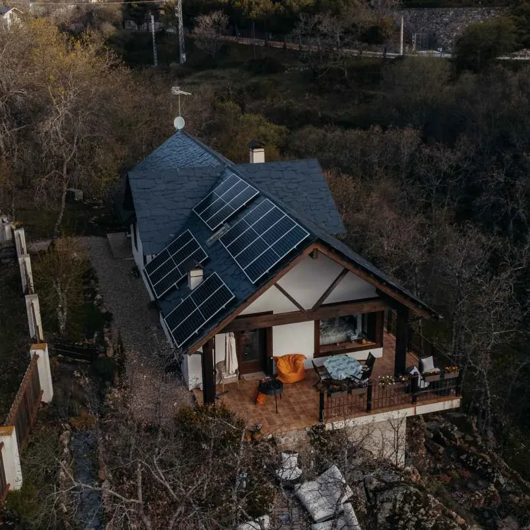 Instalación de placas solares de Lumio en un chalet con tejado de pizarra y porche de madera